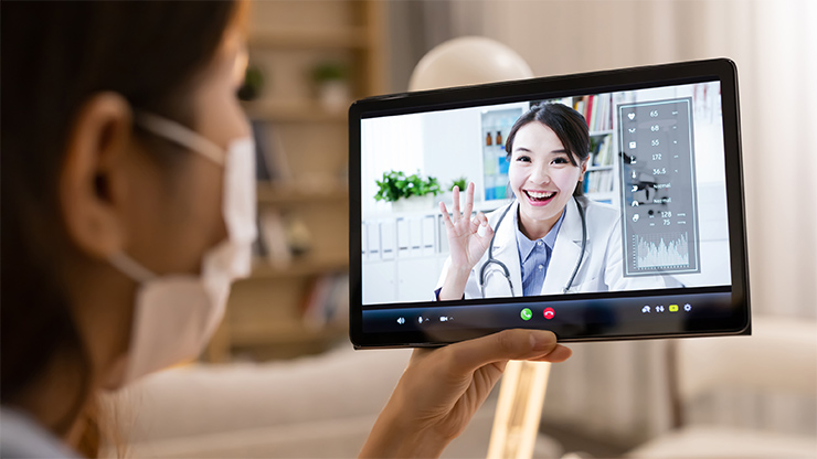 A woman using online medical review services on various devices